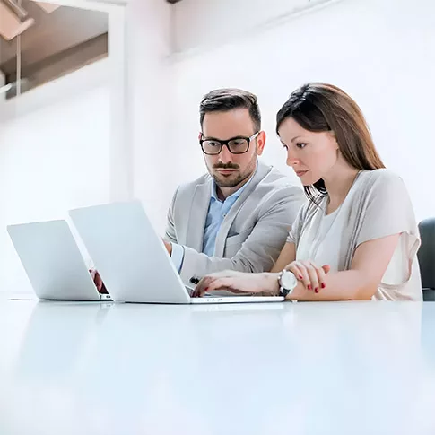 two project managers are seriously paying attention to the tasks on the laptop