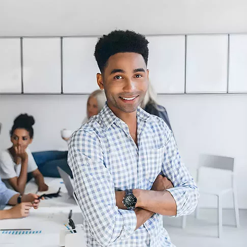 The man is smiling and standing facing the camera