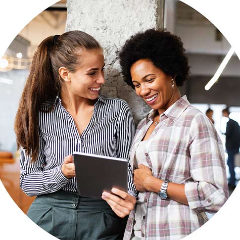 two women are discussing work on a tablet